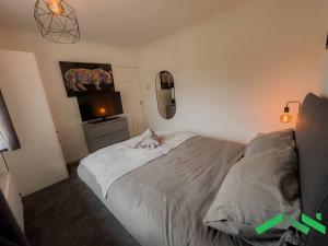 a bedroom with a cat laying on a bed at Lovely Bedroom in Modern House in Cleethorpes