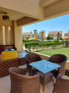 a patio with a table and chairs and a playground at Mousa Coast aquapark view chalet with garden in Ras Sedr