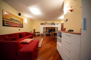 ein Wohnzimmer mit einem roten Sofa und einer Küche in der Unterkunft Milo Apartments - Hydro-massage - Sassuolo - Maranello in Casalgrande