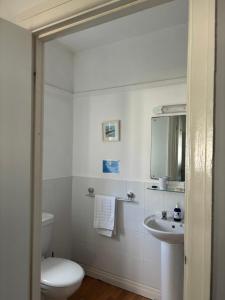a white bathroom with a toilet and a sink at The Yacht Inn in Penzance