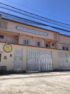 um edifício branco com um portão em frente em Maré Hostel Itapuã em Salvador