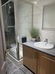 uma casa de banho com um lavatório e um chuveiro em House in Stoneywood Dyce em Aberdeen