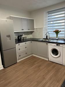uma cozinha com um frigorífico e uma máquina de lavar roupa em House in Stoneywood Dyce em Aberdeen