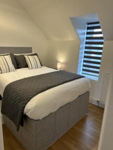 sypialnia z dużym łóżkiem i oknem w obiekcie House in Stoneywood Dyce w Aberdeen