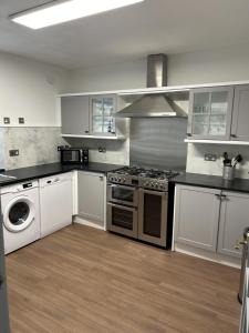 uma cozinha com um fogão e uma máquina de lavar roupa em House in Stoneywood Dyce em Aberdeen