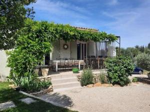 ein Haus mit einer Pergola mit einem Tisch und einer Bank in der Unterkunft Villa en Provence piscine au calme entre Arles Nîmes Avignon in Beaucaire