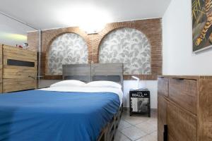 a bedroom with a blue bed and two windows at TonyHouse in Casal Palocco