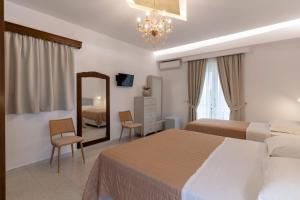 a hotel room with two beds and a mirror at Hotel Villa Basil in Tsilivi +37 photos