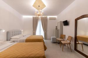 a hotel room with two beds and a chandelier at Hotel Villa Basil in Tsilivi
