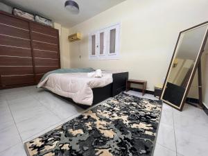 a bedroom with a bed and a mirror and a rug at 2Brs Downtown Heliopolis l Near services in Cairo