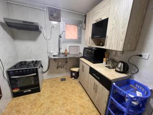 a small kitchen with a stove and a sink at 2Brs Downtown Heliopolis l Near services in Cairo