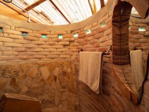 uma casa de banho em pedra com toalhas penduradas numa parede de tijolos em 1 bedroom apartment with bay view, 3 blocks from beach and center of San Juan em San Juan del Sur