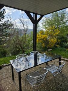 una mesa de cristal y 2 sillas en el patio en Große Ferienwohnung in ruhiger Lage mit toller Aussicht in Triberg, en Triberg