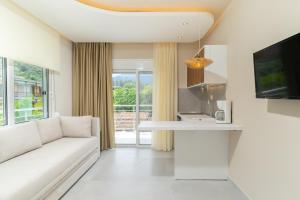 a living room with a white couch and a tv at Port Oasis in Limenas