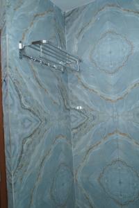 una puerta de ducha de cristal con toallero en JB Hotel and Resort en Lohaghāt