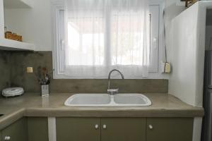a kitchen counter with a sink and a window at Navis apartment in Triovasálos