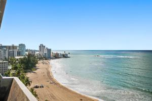 a view of a beach with buildings and the ocean at Oceanfront Paradise - Spacious and Family Friendly in San Juan