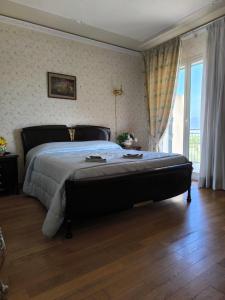 a bedroom with a large bed and a large window at Bed & Breakfast Kalinka in Motta SantʼAnastasia