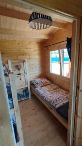 Habitación con cama en una cabaña de madera en Drewniane domki - Zamek Krzyżacki en Malbork