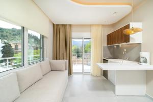 a living room with a white couch and a large window at Port Oasis in Limenas