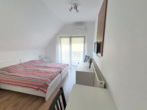 um quarto branco com uma cama e uma janela em Pensiunea Nossa Panzió em Corunca