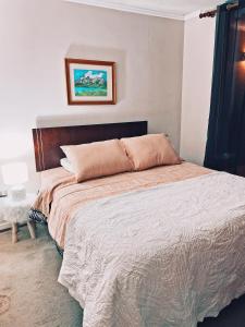 een slaapkamer met een groot bed met een houten hoofdeinde bij Depto con acceso a playa privada in San Pedro de la Paz