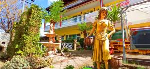 Una statua di una donna in piedi di fronte a un edificio di Комплекс "Тера Верде" a Oreshak