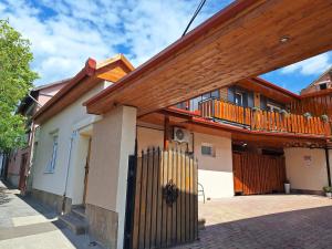 a house with a wooden fence in front of it at Várfal apartman II in Eger