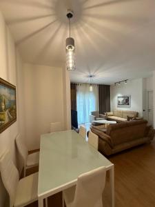 ein Wohnzimmer mit einem weißen Tisch und einem Sofa in der Unterkunft Lake Escape - Home 2 in Tirana