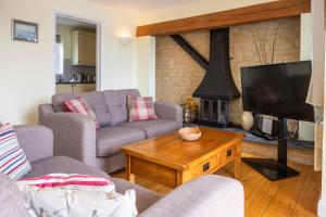a living room with two couches and a fireplace at Mill Village 75, Tide Cottage - P in Somerford Keynes