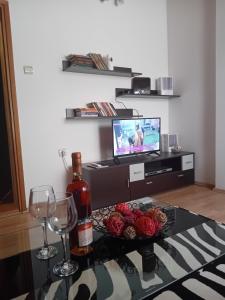 a living room with a table with a bottle of wine and wine glasses at Šumska Vila in Bajina Bašta