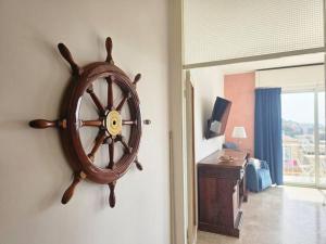 um relógio de roda de madeira numa parede num quarto em Parking,WiFi, Netflix - Sunny Sea View Haven em Rapallo