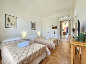 um quarto com 2 camas e uma secretária e um quarto em Parking,WiFi, Netflix - Sunny Sea View Haven em Rapallo