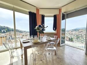 uma sala de jantar com mesa, cadeiras e janelas em Parking,WiFi, Netflix - Sunny Sea View Haven em Rapallo