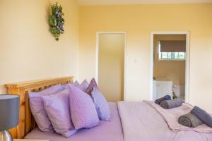 a bedroom with two beds with purple pillows at Pierocks Highgate Entire house Free Parking and WI-FI in Arnos Vale