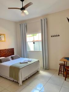 a bedroom with a bed and a ceiling fan at Pousada Aconchego De São Thomé in São Thomé das Letras