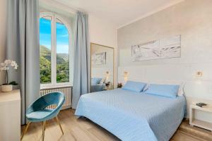 a bedroom with a blue bed and a large window at Dreams Guest House in La Spezia