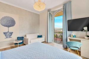 1 dormitorio con cama, sofá y TV en Dreams Guest House, en La Spezia