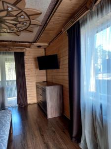 um quarto com uma cama e uma televisão de ecrã plano em Voyage Tatariv em Tatariv