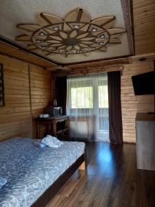 - une chambre avec un lit et un ventilateur de plafond dans l'établissement Voyage Tatariv, à Tatariv