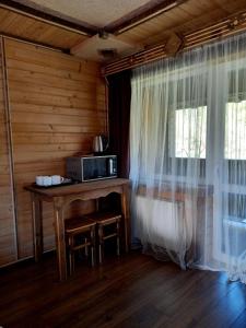 um quarto com uma mesa com um micro-ondas e uma janela em Voyage Tatariv em Tatariv