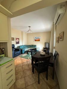 uma sala de estar com uma mesa e cadeiras e um sofá em Sol Central Apartament em Durrës