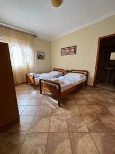 two beds are in a room with a tile floor at Sol Central Apartament in Durrës
