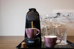 a coffee maker and two cups on a table at FLOARA DI MUNTE Forest Luxury Suites in Metsovo