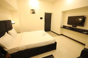 Cette chambre comprend un lit et une télévision à écran plat. dans l'établissement Hotel Parashar Palm, à Nagpur