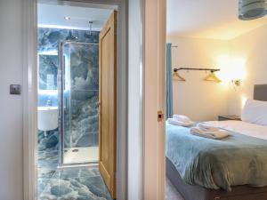 a bedroom with a shower and a bed at 1 Ty Newydd in Porthmadog