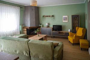 a living room with a couch and a tv at Spacious and comfy apartment in Nea Moudania
