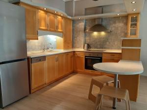 a kitchen with wooden cabinets and a table and a sink at Spacious and comfy apartment in Nea Moudania