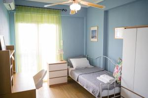 a small bedroom with a bed and a ceiling fan at Spacious and comfy apartment in Nea Moudania
