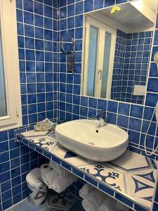 ポンツァにあるb&b da Lauraの青いタイル張りのバスルーム(洗面台、トイレ付)